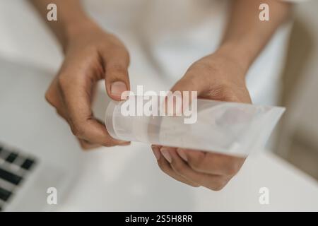 Donne che indossano camicie bianche che premono il gel per lavarsi le mani e pulire le mani. Foto Stock