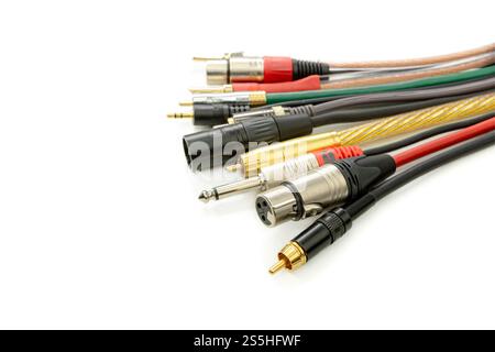 Ampia gamma di cavi e connettori audio su sfondo bianco Foto Stock