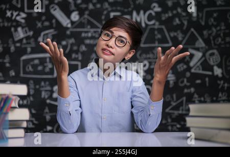 L'insegnante sedeva pensando di insegnare in classe Foto Stock