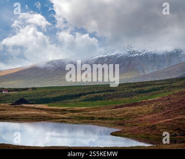 Splendida vista sulle montagne durante il viaggio in auto in Islanda. Spettacolare paesaggio islandese con natura panoramica: Montagne, campi, nuvole, laghi, ghiacciai. Foto Stock