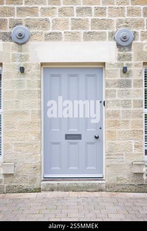 Porta d'ingresso in legno dipinto di grigio per un appartamento in un antico mulino convertito. Nidderdale, Yorkshire Dales, Regno Unito Foto Stock