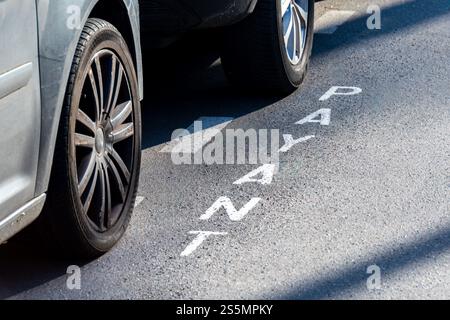 Segnaletica stradale "PAYANT" scritta in francese che indica un parcheggio a pagamento in una strada di Parigi, Francia. Concetti di prezzi dei parcheggi in Francia Foto Stock