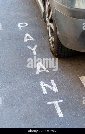 Segnaletica stradale "PAYANT" scritta in francese che indica un parcheggio a pagamento in una strada di Parigi, Francia. Concetti di prezzi dei parcheggi in Francia Foto Stock