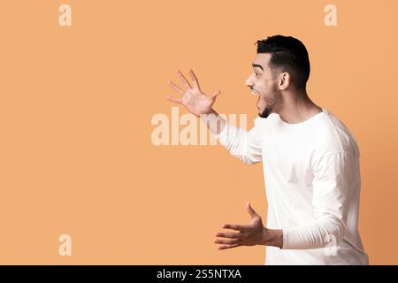 Grande fortuna. Coppia mediorientale gioiosa che alza le mani e esclama con entusiasmo Foto Stock