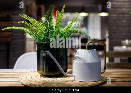 Piante verdi di plastica artificiale sul tavolo in casa appartamento Foto Stock