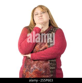 Una donna di mezza età con un maglione a motivi rossi si erge con il mento appoggiato sulla mano e un braccio incrociato, trasudando fiducia e un demea premuroso Foto Stock