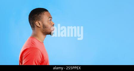 Vista laterale Ritratto di grave African American Man su sfondo blu Foto Stock
