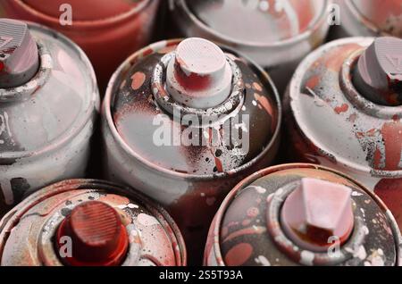 Molti spray usati per primi piani. Lattine sporche e macchiate per disegnare graffiti. Il concetto di un disegno di vernice spazzatura e disinvolto. Foto Stock
