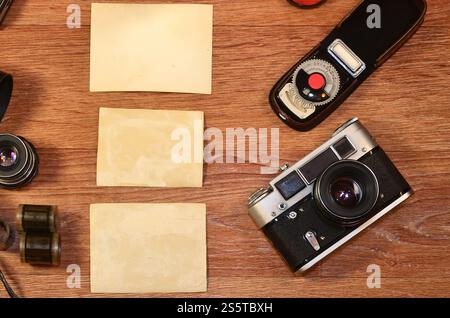 Vista superiore della foto Vintage fotocamera e altri vecchi retrò accessori fotografia sul tavolo in legno piastra con alcuni bianco chiaro vuoto photo frame per posta Foto Stock