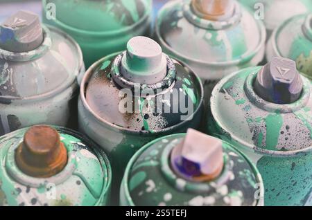 Molti spray usati per primi piani. Lattine sporche e macchiate per disegnare graffiti. Il concetto di un disegno di vernice spazzatura e disinvolto. Foto Stock