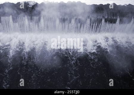 Diga per regolare il livello dell'acqua nel fiume. Bianco e nero in caduta d'acqua con forti esplosioni. Caduta di acqua con forti scoppi Foto Stock