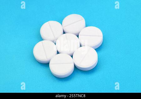 Un paio di compresse bianche giacciono su un blu brillante superficie di sfondo. Immagine di sfondo sul farmaceutico e medico, argomenti Foto Stock