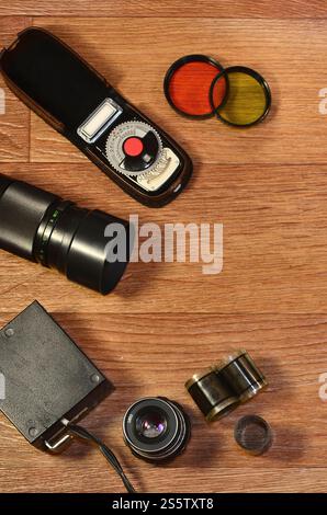 Vista dall'alto della fotocamera d'epoca e di altri vecchi accessori fotografici retrò su un tavolo in legno con molto spazio immacolato. Natura morta con la vecchia fotografia Foto Stock