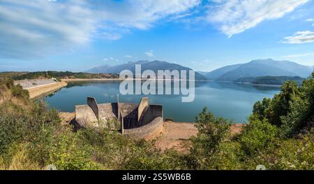 Debar paesaggio estivo del lago con costruzione di drenaggio dell'acqua vicino alla centrale idroelettrica di Shpilje, e sullo sfondo delle montagne. Macedonia del Nord no Foto Stock