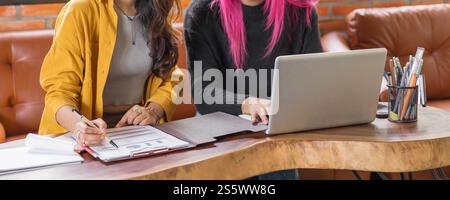 LGBTQ+ transgender uomo bellissimo autentico Specialista con capelli rosa e trans non binari che lavorano insieme Design nel team creativo del luogo di lavoro Foto Stock
