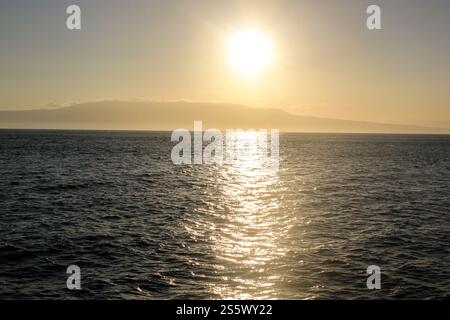 Tramonto dorato sull'oceano con un sole splendente, riflesso scintillante sull'acqua, Isole Galapagos, Ecuador. Foto Stock