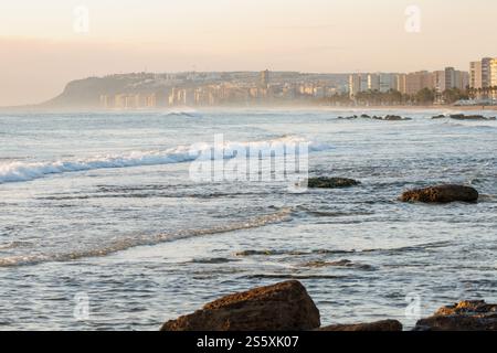 Paesaggio marino dell'alba con la nebbia di Arenales del Sol dalla spiaggia di Agua Amarga, Alicante, Spagna Foto Stock
