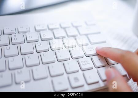 Mani di donna d'affari dito indice premendo il tasto invio sulla tastiera del computer Foto Stock