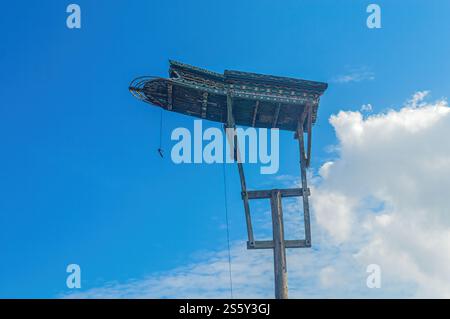 una tradizionale casa di colomba in legno su una colonna su uno sfondo blu nuvoloso del cielo Foto Stock