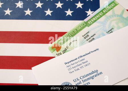 La carta verde permanente residente degli Stati Uniti dalla lotteria dv si trova sulla bandiera degli Stati Uniti con la busta del Department of Homeland Security Close Up. Foto Stock