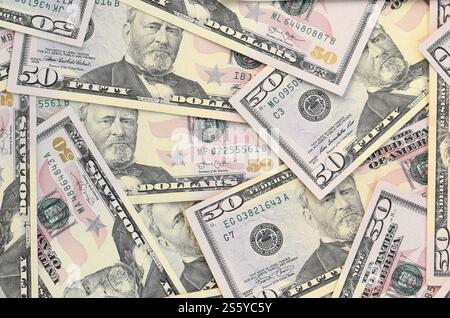 Molte banconote da cinquanta dollari su una superficie piana di fondo in primo piano. Vista dall'alto in posizione piatta. Concetto di successo astratto o di business. Molte banconote da cinquanta dollari Foto Stock