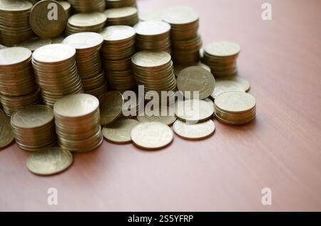 Grande quantità di lucide monete ucraine vecchie di 1 hryvnia da vicino su sfondo di legno. Il concetto di affari e di vita ricca in Ucraina. Grande quantità Foto Stock