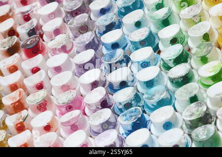 Un motivo da molti ugelli di un'irroratrice per disegnare graffiti, spalmati in colori diversi. I tappi in plastica sono disposti in molte file Foto Stock