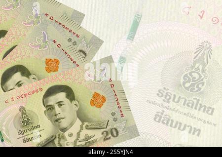20 banconote thailandesi in Baht sono impilate sullo sfondo di grandi banconote semitrasparenti. Sfondo aziendale astratto con spazio di copia. 20 bollette thailandesi Foto Stock