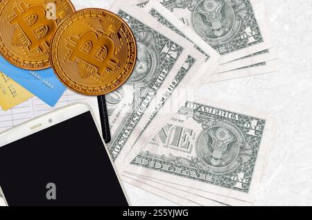 Banconote da 1 dollaro USA e bitcoin dorati con smartphone e carte di credito. Concetto di investimento in criptovaluta. Transazioni di mining o trading di criptovalute. 1 Foto Stock