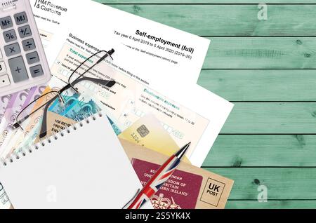 Modulo fiscale inglese sa103 lavoro autonomo da HM revenue and Customs si trova sul tavolo con gli articoli per ufficio. Documentazione HMRC e processo di pagamento delle tasse in United Foto Stock