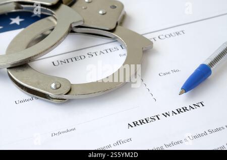 Documenti del tribunale distrettuale con manette e penna blu sulla bandiera degli Stati Uniti. Concetto di permesso per arrestare un sospetto. Distretto Foto Stock