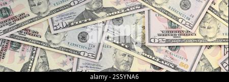 Molte banconote da cinquanta dollari su una superficie piana di fondo in primo piano. Vista dall'alto in posizione piatta. Concetto di successo astratto o di business. Molte banconote da cinquanta dollari Foto Stock
