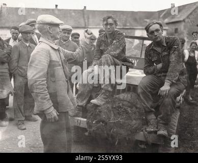 Un vecchio mostra il suo pugno ai soldati catturati della 12a Divisione Panzer delle SS - Gioventù hitleriana. - Documento storico, fotografo sconosciuto Foto Stock