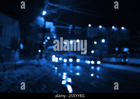 Notti luci della grande città, la notte sfocata avenue con bokeh semaforo ed i fari delle automobili in avvicinamento. Foto Stock