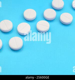 Un paio di compresse bianche giacciono su un blu brillante superficie di sfondo. Immagine di sfondo sul farmaceutico e medico, argomenti Foto Stock