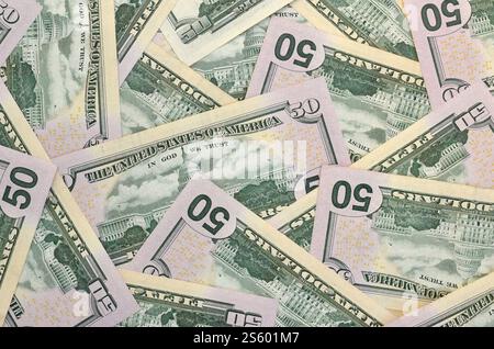 Molte banconote da cinquanta dollari su una superficie piana di fondo in primo piano. Vista dall'alto in posizione piatta. Concetto di successo astratto o di business. Molte banconote da cinquanta dollari Foto Stock