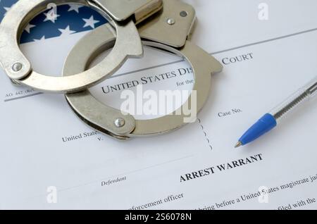 Documenti del tribunale distrettuale con manette e penna blu sulla bandiera degli Stati Uniti. Concetto di permesso per arrestare un sospetto. Distretto Foto Stock