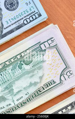 Pile di banconote da centocinquanta dollari su fondo in legno da vicino. Vista dall'alto in posizione piatta. Concetto di successo astratto o di business. Foto Stock