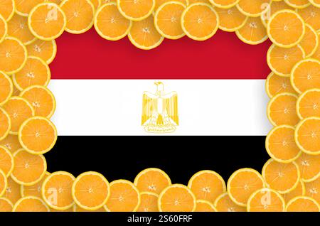 Bandiera egiziana nella cornice di fette di agrumi d'arancia. Concetto di coltivazione, importazione ed esportazione di agrumi. Bandiera dell'Egitto negli agrumi freschi Foto Stock