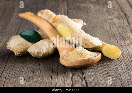 Zenzero fresco tritato e polvere di zenzero macinato in cucchiaio di legno su un tavolo rustico in legno. Cibo sano, spezie. Zingiber officinale Foto Stock