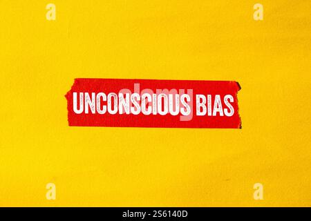 Messaggio di polarizzazione inconscia scritto su nastro strappato di carta rossa su sfondo giallo. Simbolo di pregiudizio inconscio concettuale. Copia spazio. Foto Stock