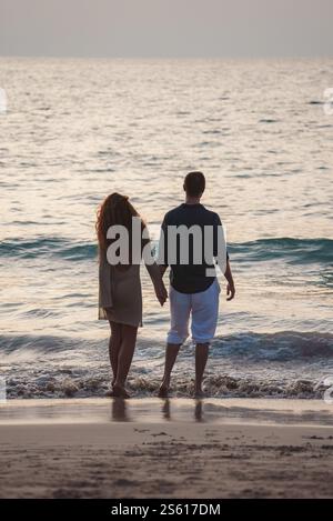 Coppia in piedi su una spiaggia di sabbia all'alba o al tramonto in Thailandia Foto Stock
