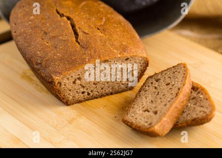 Pane fatto in casa a fette su un asse di legno. Foto Stock