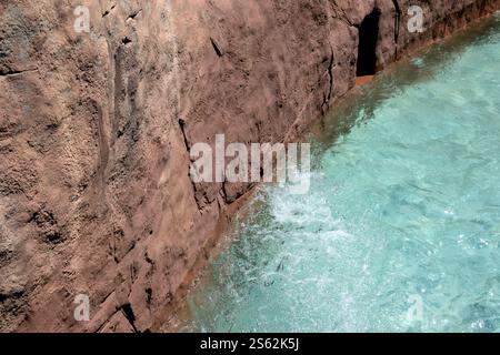 Fondo della piscina azzurro con superficie d'acqua limpida, onde sullo sfondo testurizzato Foto Stock