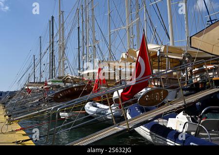 La passeggiata principale nel centro cittadino del porto di Bodrum corre lungo il porticciolo, dove gli yacht hanno bandiere turche. Foto Stock