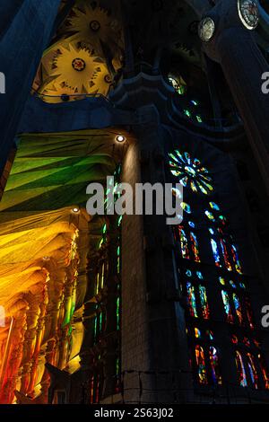 I vivaci colori dell'arcobaleno si riflettono attraverso le vetrate colorate della Sagrada Familia, creando uno splendido spettacolo di luce e colore. Foto Stock