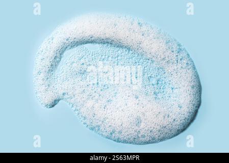 Mousse detergente per il viso o campione di shampoo su sfondo azzurro. Primo piano con texture in schiuma di sapone. Foto Stock