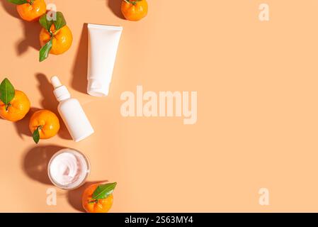 Siero di vitamina C naturale e crema viso, dermocosmesi, prodotti a base di olio essenziale. Prodotti cosmetici e succosi agrumi freschi su sfondo arancione, top vi Foto Stock