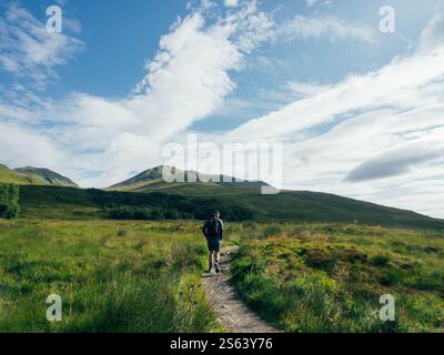 Uomo che fa trekking a Munro in Scozia in un giorno d'estate Foto Stock