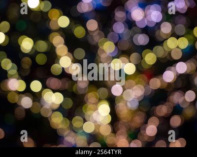 Sfondo astratto con vivaci luci bokeh in vari colori, a creare un'atmosfera festosa e magica Foto Stock